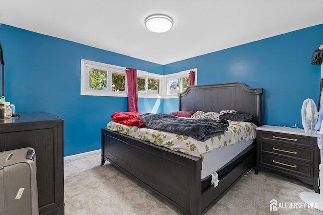 bedroom with baseboards and light colored carpet