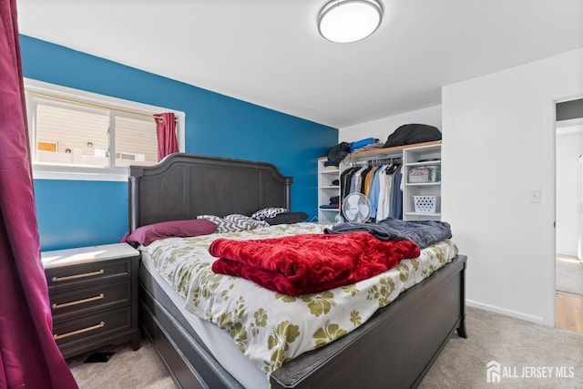 bedroom with a closet and light colored carpet