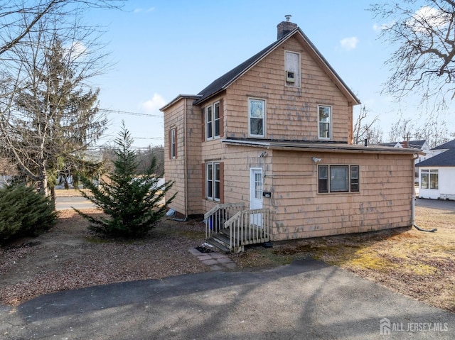 back of house with a chimney