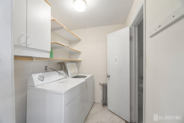 laundry area featuring marble finish floor, washing machine and clothes dryer, cabinet space, and radiator