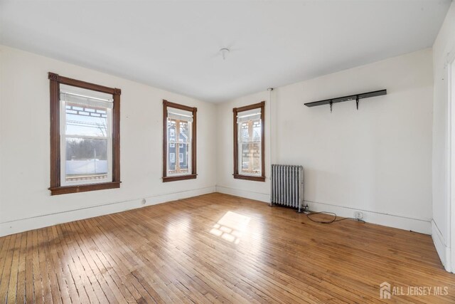 empty room featuring radiator and light hardwood / wood-style floors