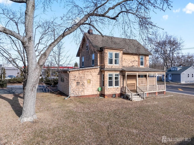 rear view of property featuring a chimney