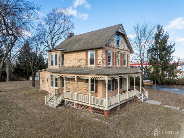 back of house featuring a lawn and a porch