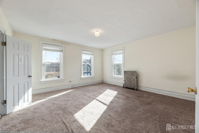 unfurnished room featuring radiator and carpet flooring