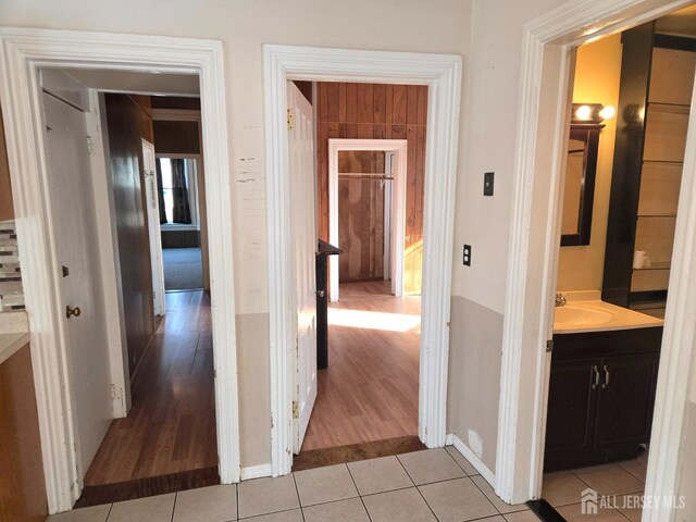 corridor featuring sink and light tile patterned floors