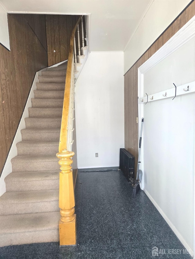 stairway featuring wood walls