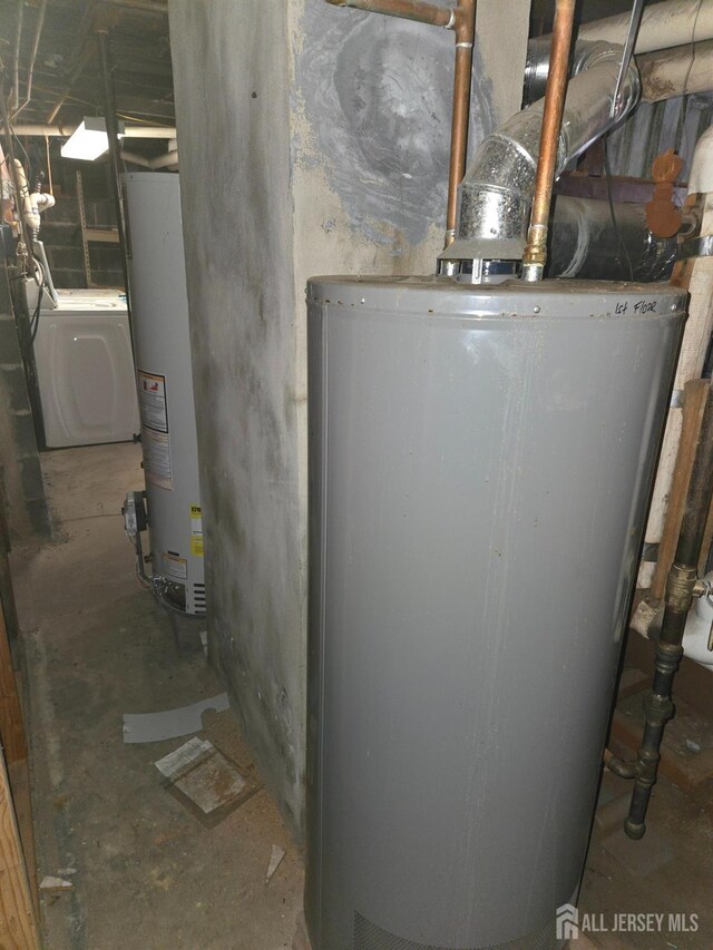 utility room with water heater and washer / dryer