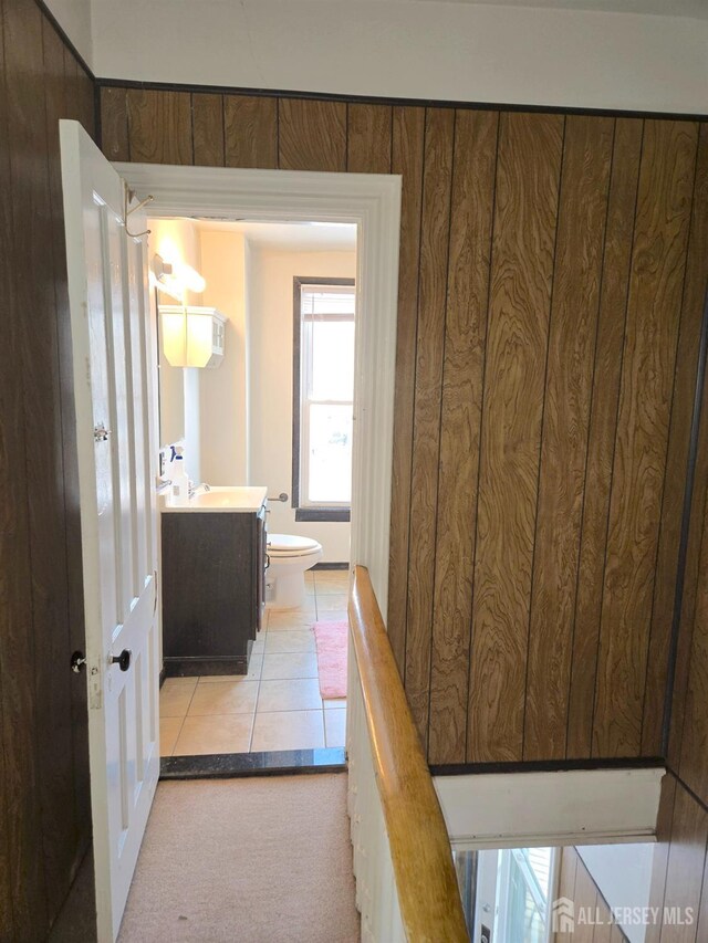 hall featuring light tile patterned floors and sink