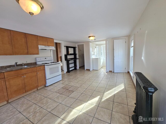 kitchen featuring sink, radiator, white electric range, and light tile patterned floors