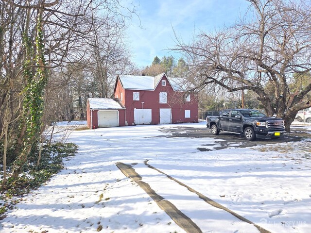 snow covered property featuring an outbuilding