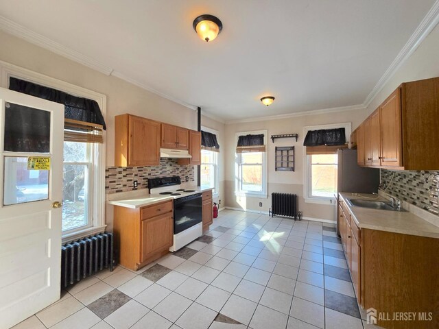 kitchen featuring electric stove, radiator heating unit, light tile patterned flooring, and sink