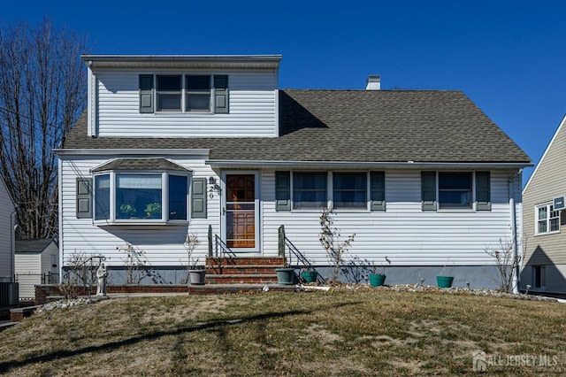 view of front of property with cooling unit, a front yard, and a shingled roof