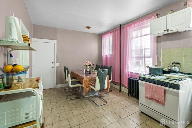 349 Livingston Ave, New Brunswick, NJ 08901 - kitchen featuring white gas range, white cabinets, radiator, and light tile patterned flooring