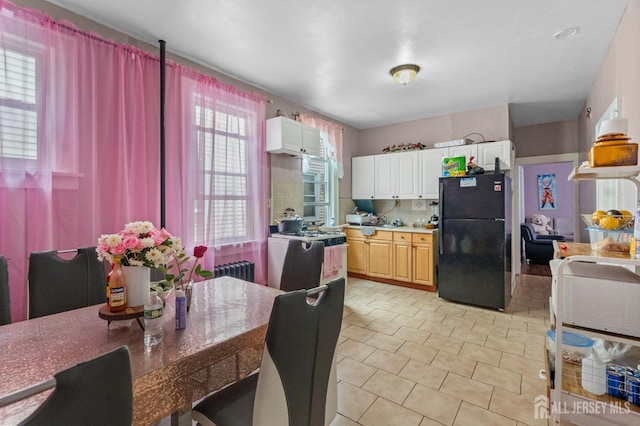 349 Livingston Ave, New Brunswick, NJ 08901 - kitchen featuring freestanding refrigerator, radiator, gas range oven, backsplash, and light tile patterned flooring