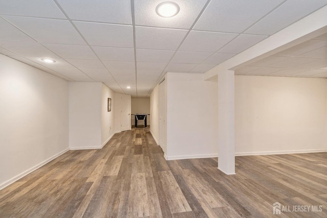 basement with a paneled ceiling and hardwood / wood-style floors