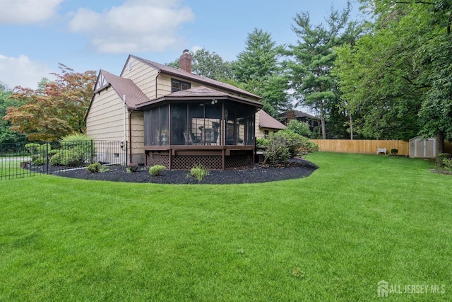 back of property featuring a lawn, a sunroom, and a storage unit