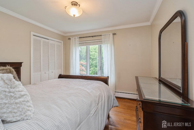 bedroom featuring hardwood / wood-style flooring, a baseboard radiator, ornamental molding, and a closet