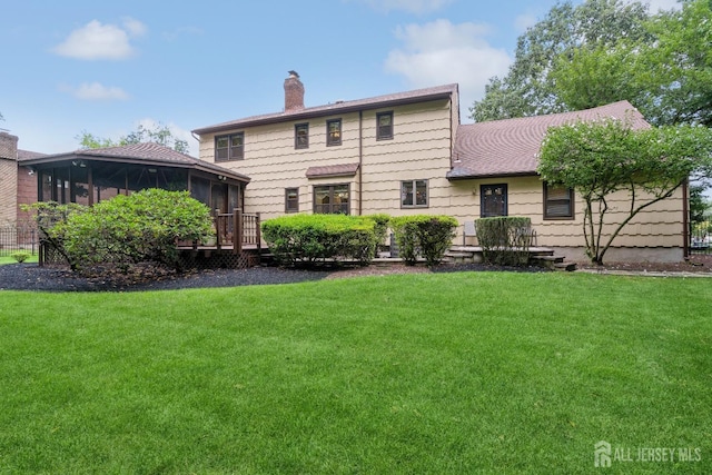 rear view of property with a yard and a sunroom