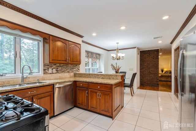 kitchen with sink, appliances with stainless steel finishes, backsplash, light stone countertops, and kitchen peninsula