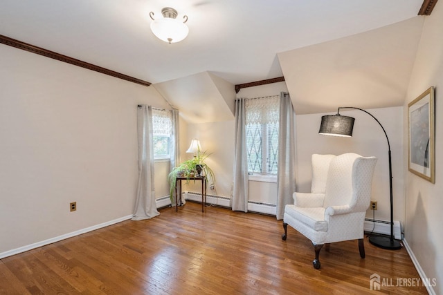 sitting room with a baseboard radiator, wood-type flooring, and vaulted ceiling