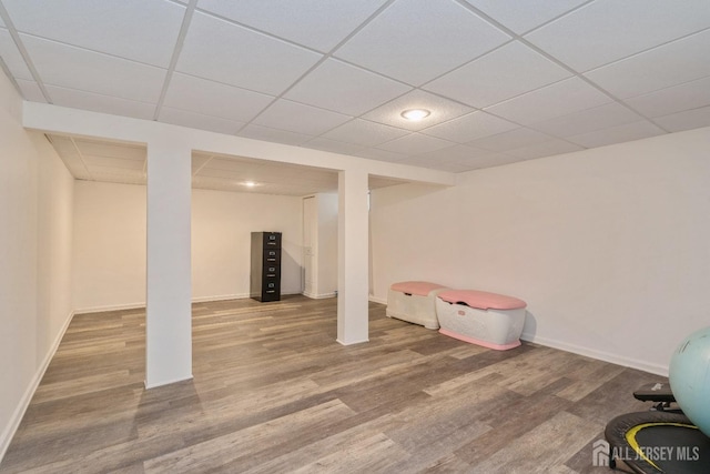 basement featuring hardwood / wood-style flooring and a paneled ceiling