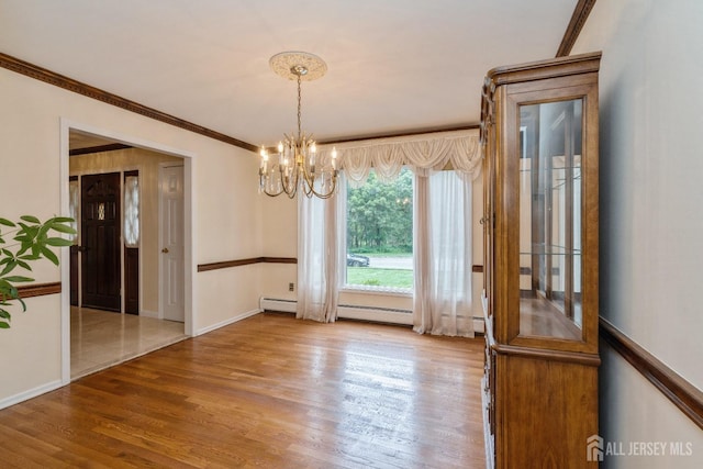 unfurnished dining area with hardwood / wood-style flooring, crown molding, and a chandelier