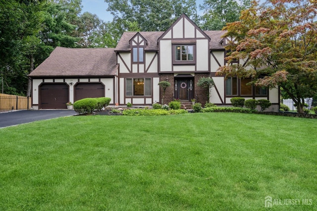 english style home with a garage and a front lawn