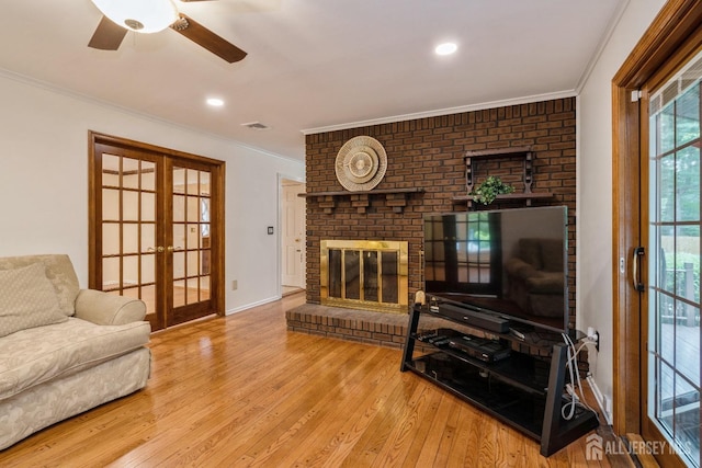 living room with hardwood / wood-style flooring, ornamental molding, and french doors