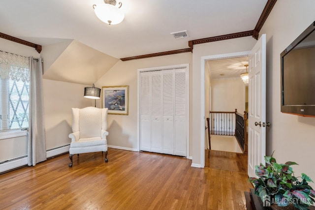 unfurnished room featuring baseboard heating and light wood-type flooring