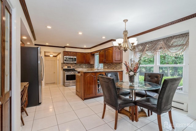 tiled dining area with an inviting chandelier, a baseboard radiator, ornamental molding, and sink