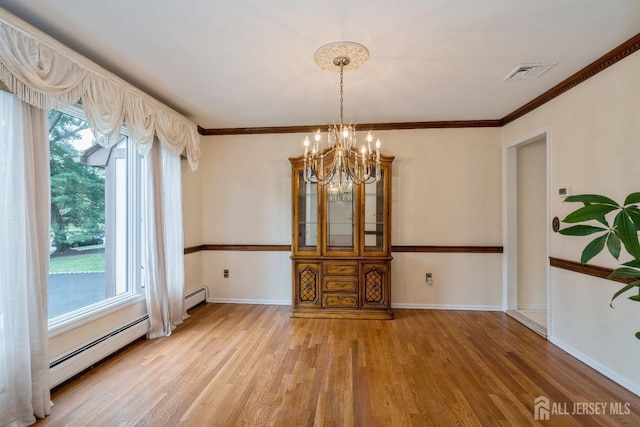 unfurnished dining area with crown molding, a baseboard heating unit, a notable chandelier, and wood-type flooring