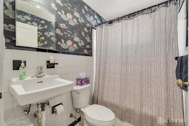 bathroom featuring sink, toilet, and tile walls