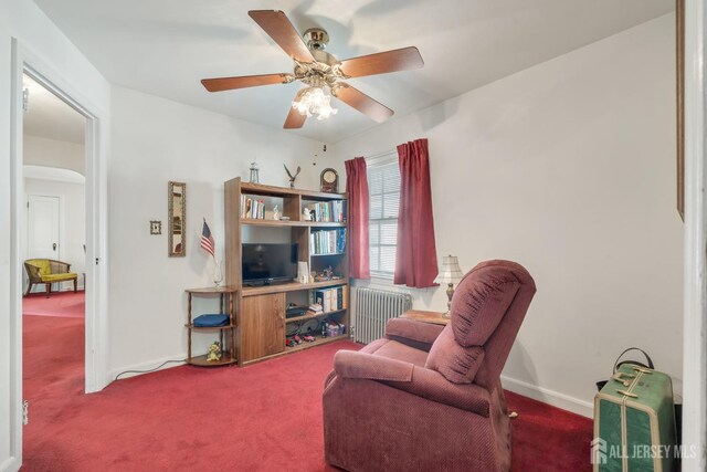 sitting room featuring ceiling fan, carpet, and radiator heating unit