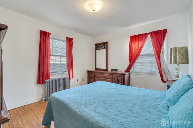 bedroom featuring light wood-type flooring and radiator heating unit