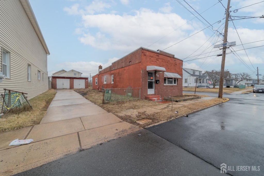 73 Daniel St, Port Reading, NJ 07064 - view of side of property with an outbuilding, a residential view, driveway, and entry steps