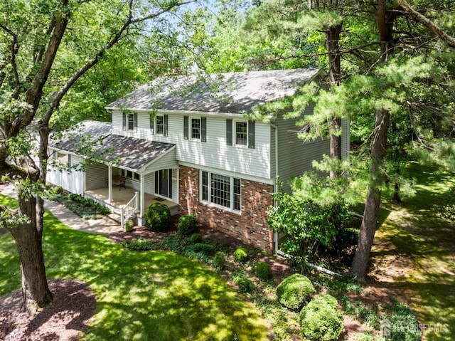 19 Redcoat Dr, East Brunswick, NJ 08816 - view of front of house with covered porch, brick siding, roof with shingles, and a front yard