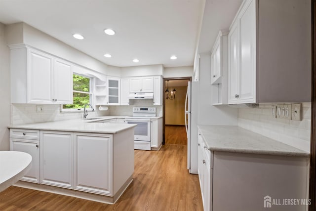 19 Redcoat Dr, East Brunswick, NJ 08816 - kitchen with white appliances, a peninsula, under cabinet range hood, white cabinets, and recessed lighting