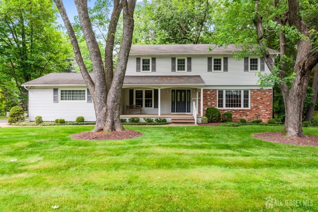19 Redcoat Dr, East Brunswick, NJ 08816 - view of front of home featuring covered porch, a front lawn, and brick siding