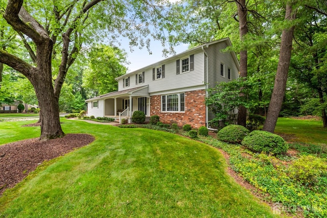 19 Redcoat Dr, East Brunswick, NJ 08816 - view of front facade with brick siding, a porch, and a front yard