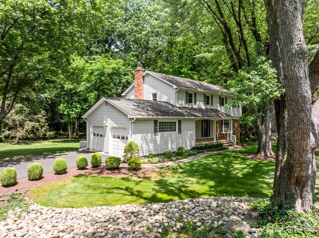 19 Redcoat Dr, East Brunswick, NJ 08816 - traditional-style house with driveway, an attached garage, and a front lawn