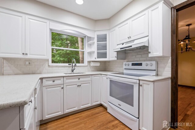 19 Redcoat Dr, East Brunswick, NJ 08816 - kitchen with white electric range, under cabinet range hood, white cabinetry, tasteful backsplash, and light wood finished floors