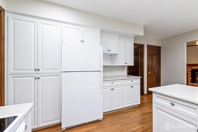 19 Redcoat Dr, East Brunswick, NJ 08816 - kitchen with freestanding refrigerator, light wood-type flooring, white cabinetry, and light stone countertops