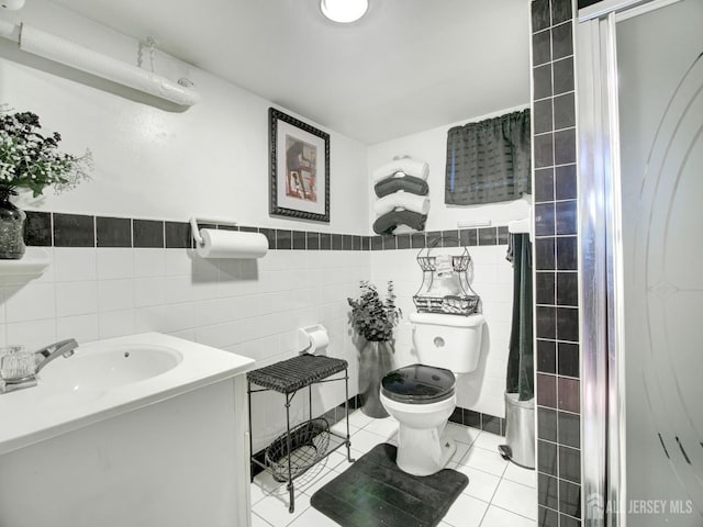 bathroom featuring tile walls, toilet, tile patterned floors, vanity, and a shower