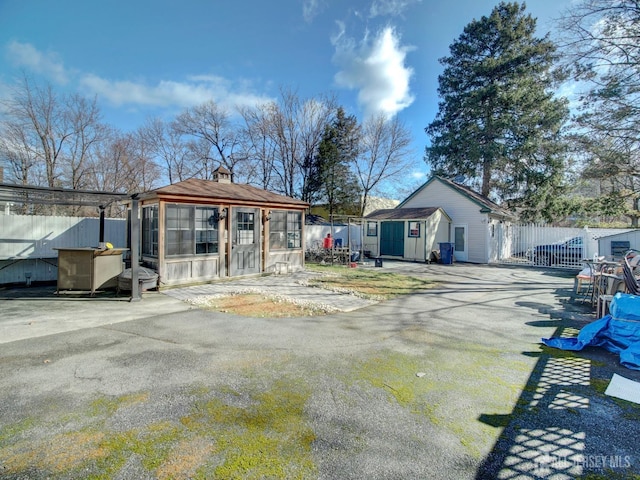 back of property with a chimney, an outdoor structure, and fence