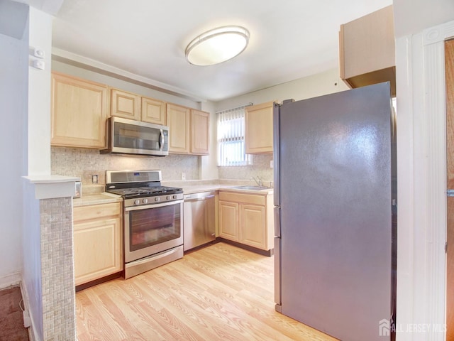 kitchen featuring light countertops, appliances with stainless steel finishes, light wood-style flooring, and light brown cabinetry