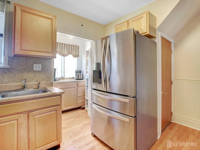 kitchen featuring a sink, light brown cabinetry, stainless steel fridge with ice dispenser, and light wood-type flooring