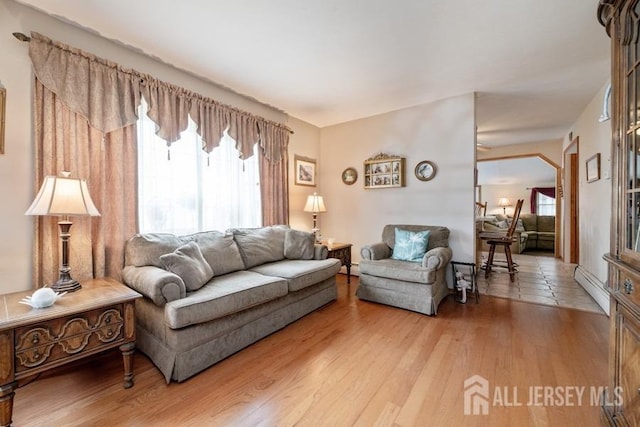 living room featuring baseboard heating, light wood-style floors, and a baseboard heating unit