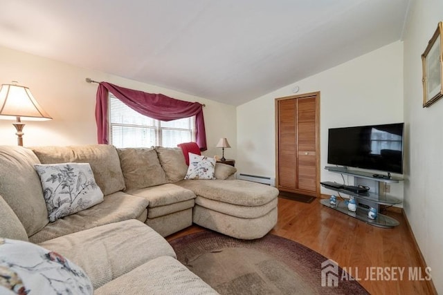 living area with vaulted ceiling, wood finished floors, and baseboard heating