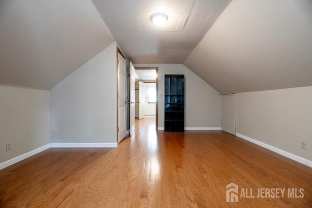 bonus room featuring wood finished floors, lofted ceiling, and baseboards