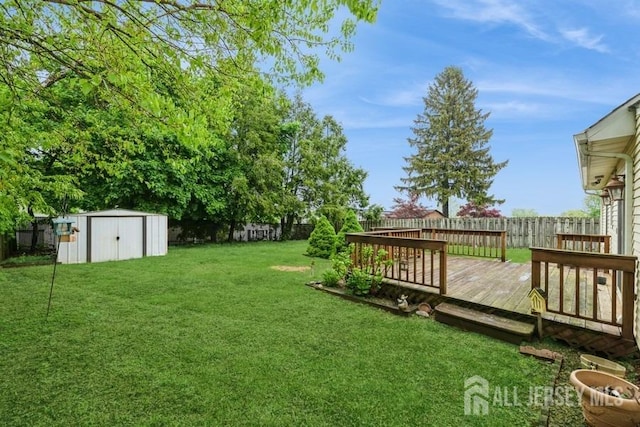 view of yard featuring a storage unit, an outdoor structure, and a wooden deck